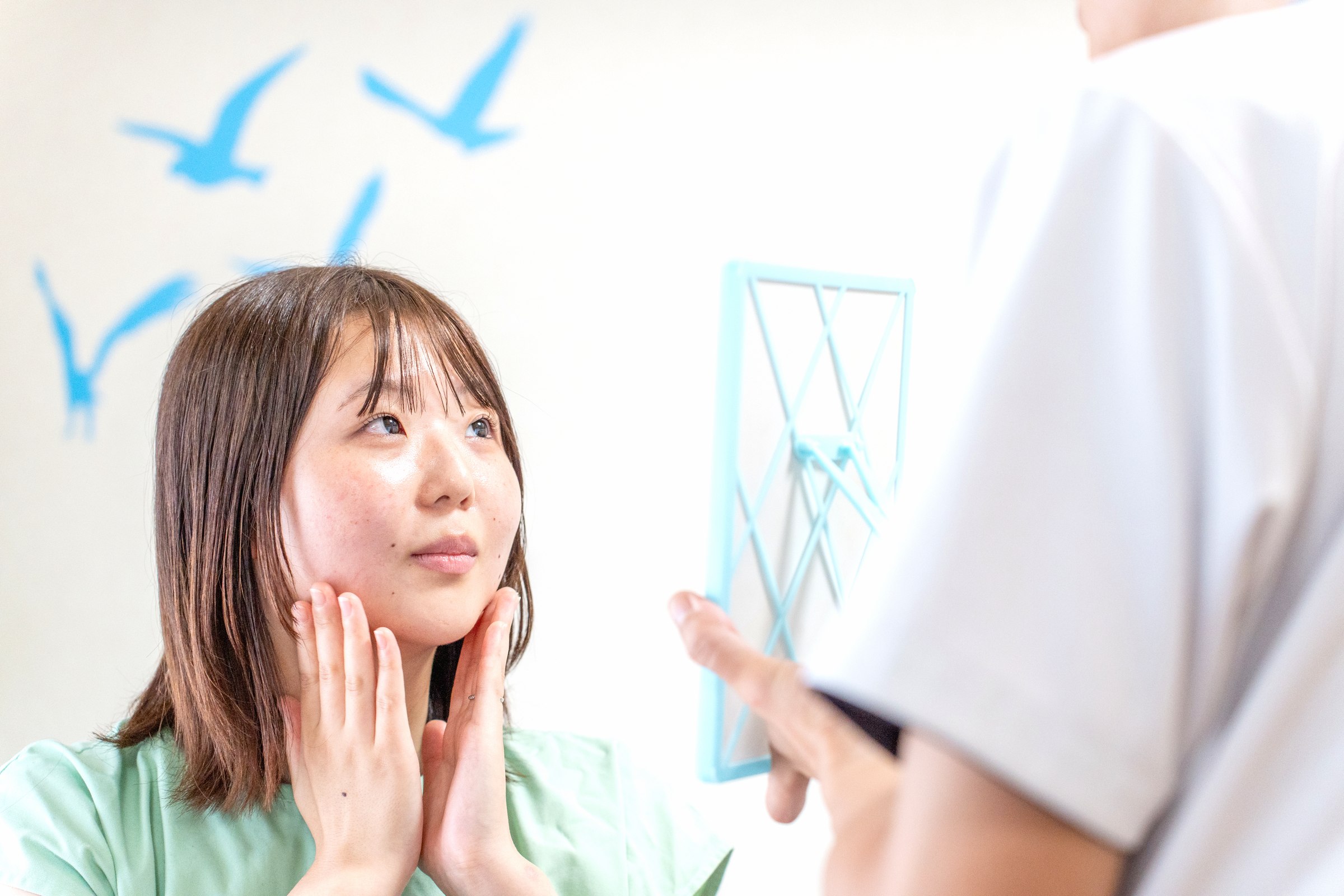 鏡を見ながら自分の肌の変化に向き合う女性